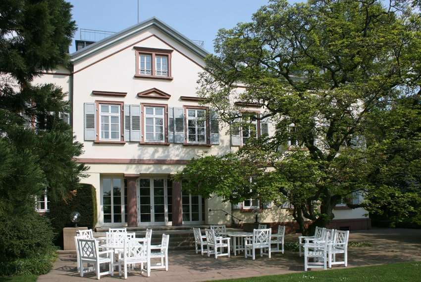 Aussenbereich der Villa im Sommer mit weißen Tischen und Stühlen